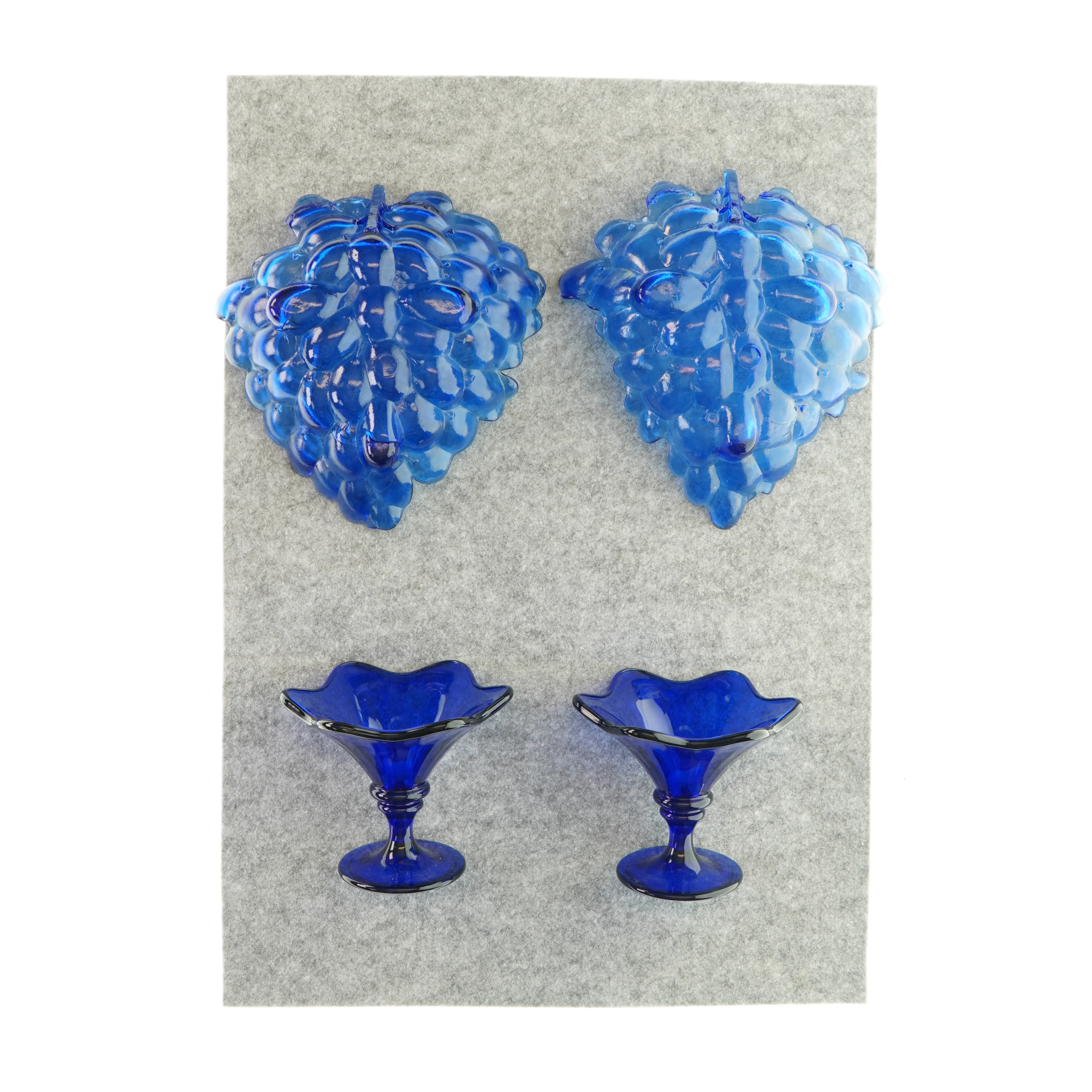 To fade og to skåle på fødder i blåt glas