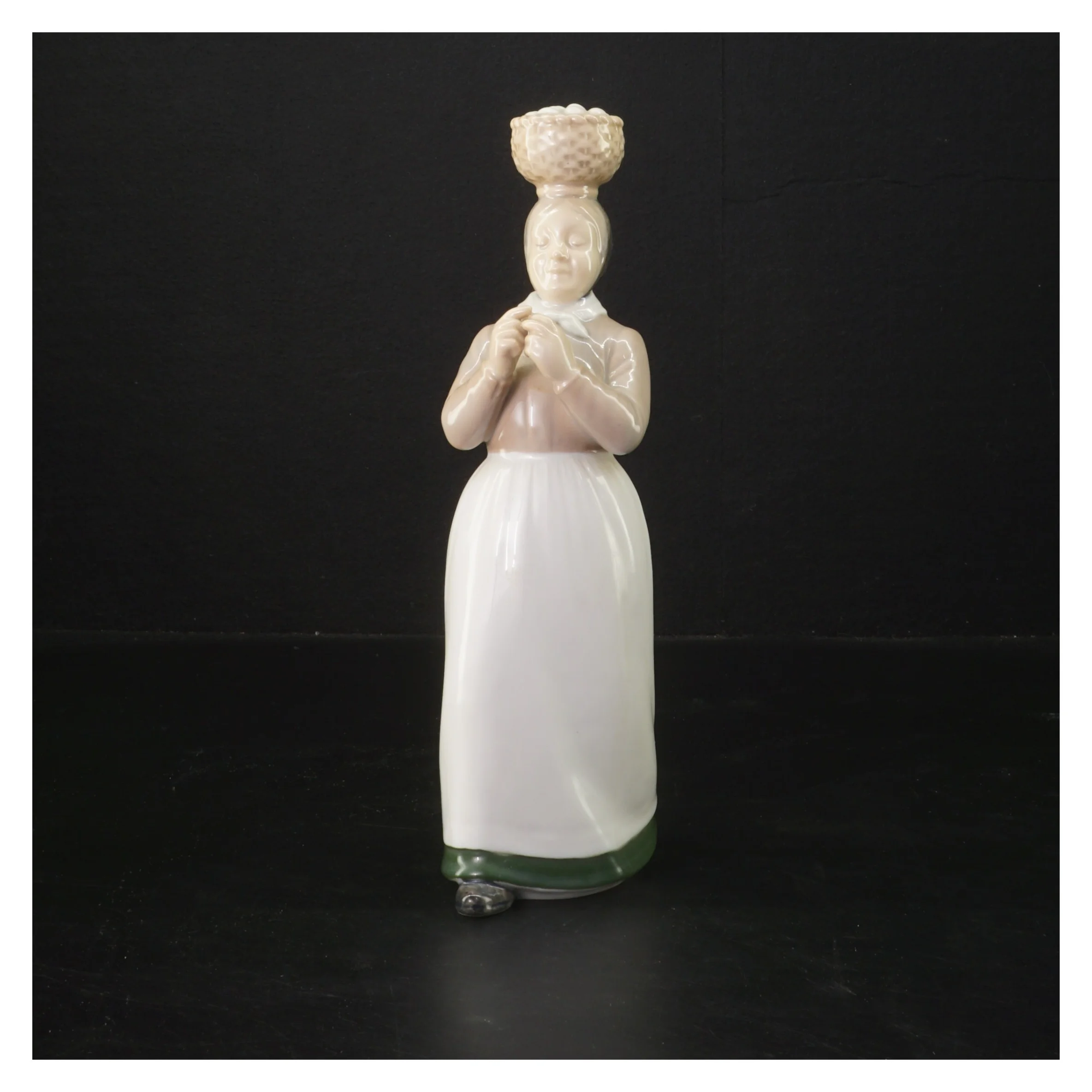 Porcelænsfigur af kvinde med kurv fra Bing Og Grøndal (str. 22 cm)