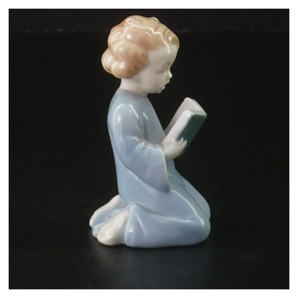 Lille porcelænsfigur læsende barn (str. 9 cm)