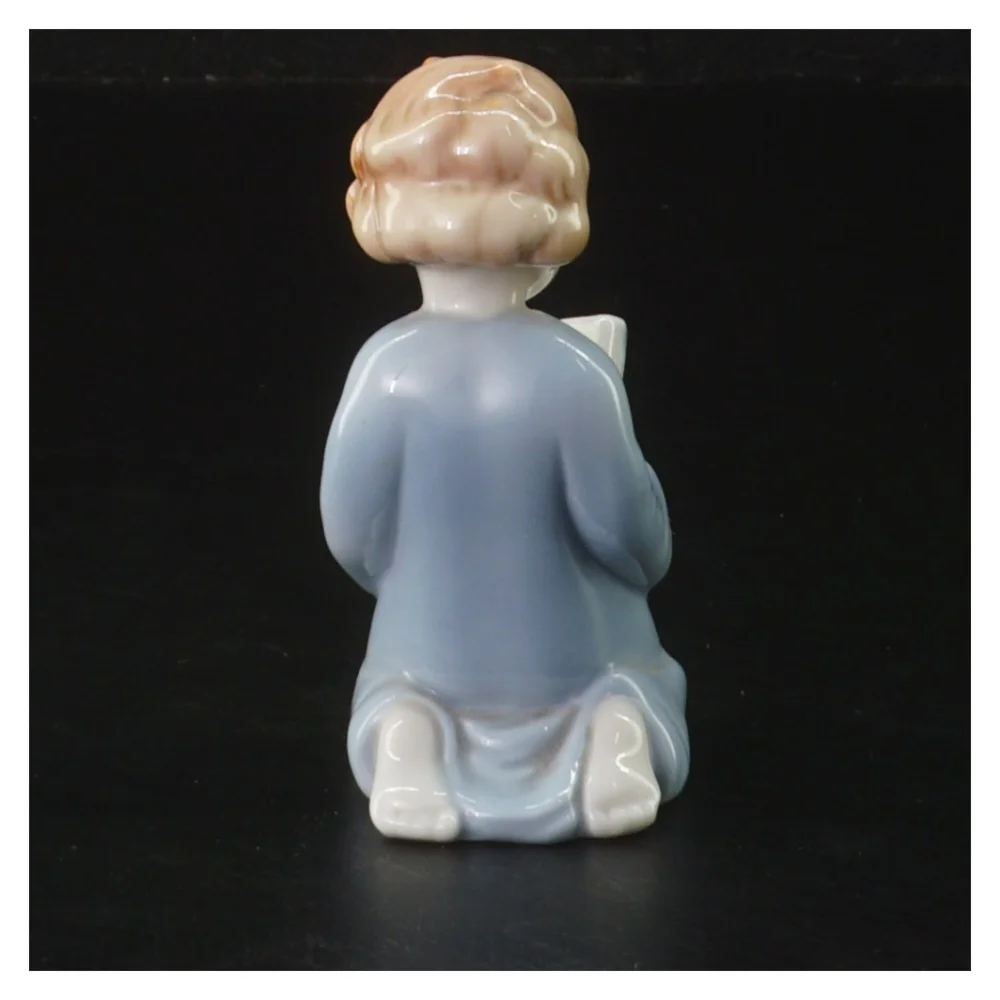 Lille porcelænsfigur læsende barn (str. 9 cm)