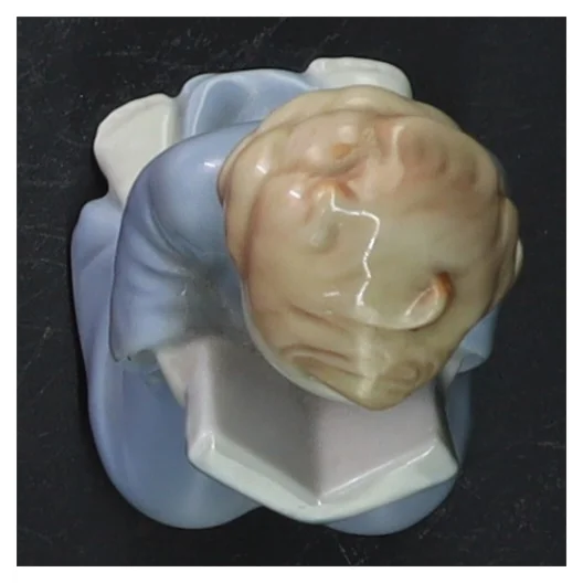 Lille porcelænsfigur læsende barn (str. 9 cm)