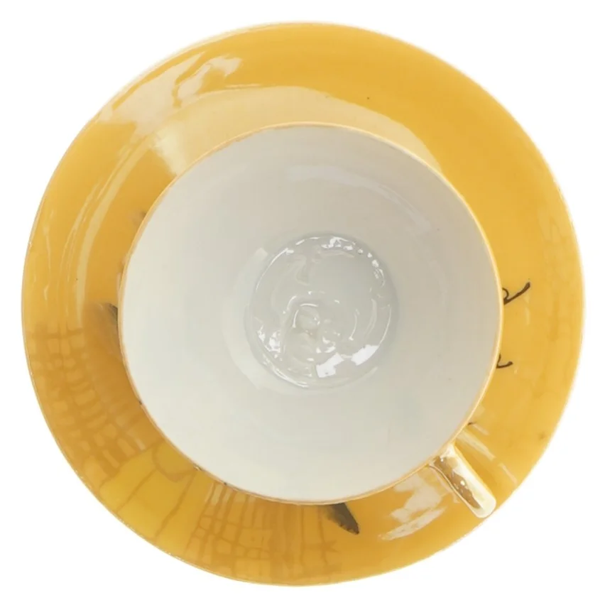 Mokkakop med ansigt i bunden 