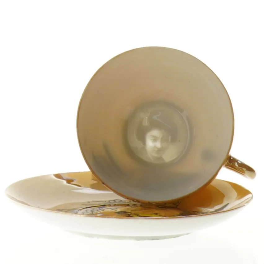 Mokkakop med ansigt i bunden 