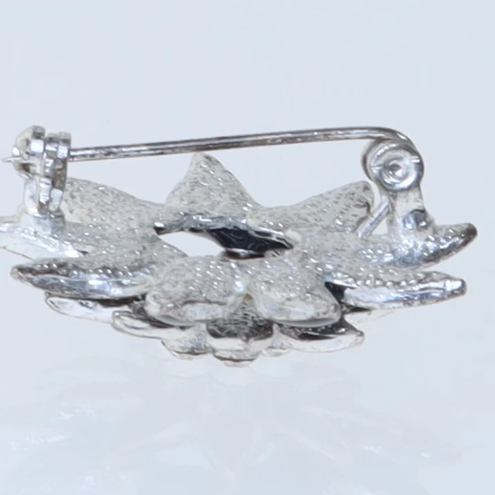 Blomstformet broche i sort (str. 3,5 cm)