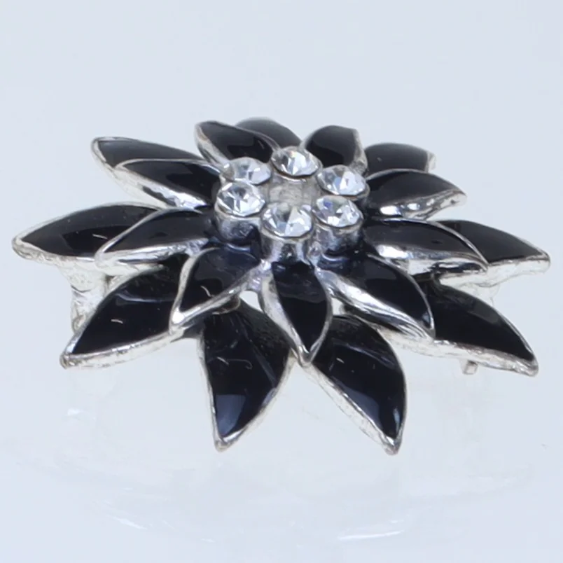 Blomstformet broche i sort (str. 3,5 cm)