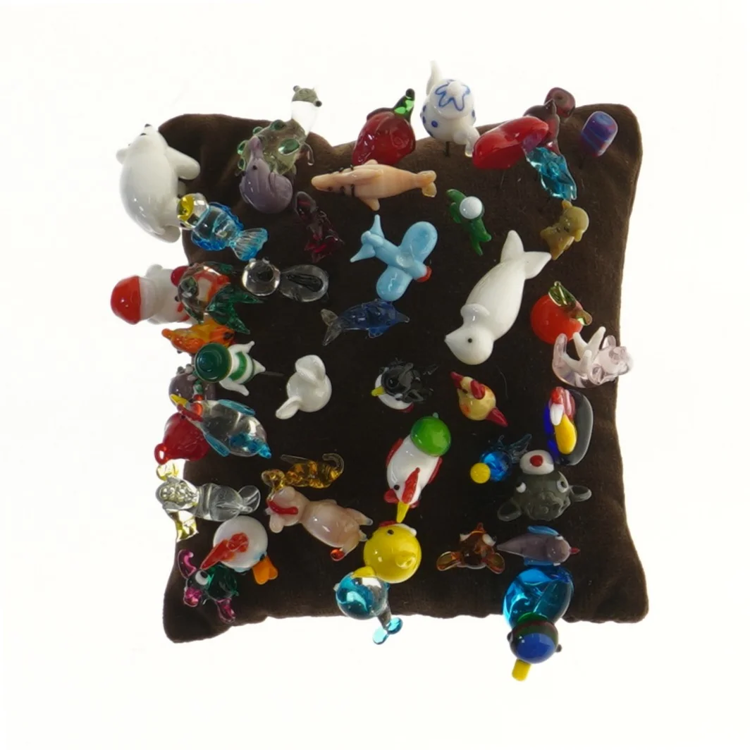 Samling af nipsenåle på pude (str. 15x15 cm)